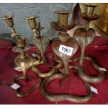 A pair of Indian brass cobra pattern candlesticks - sold with a smaller pair and three similar