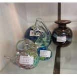 Four pieces of Mdina glass comprising three paperweights and a vase