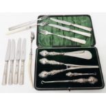 A cased silver handled button hooks, glove stretcher and shoe horn set with ornate embossed