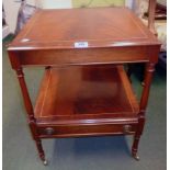 An 18 1/4" reproduction mahogany two tier table with turned supports and drawer under, set on turned
