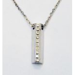 An import marked 750 white gold diamond encrusted ingot style pendant, on similarly marked chain