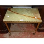 A vintage brass tea table with green onyx top and castors