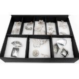 A fitted box containing a collection of white metal filigree jewellery and Siam nielo work brooches