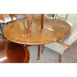 A 6' 5" mahogany and rosewood cross banded oval tilt-top dining table, set on turned pillar and