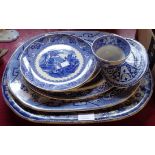 Four graduated meat plates of differing designs and four other blue and white ceramics including