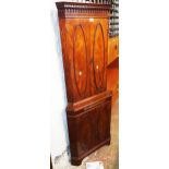 A 23 1/2" Bevan Funnell "Reprodux" flame mahogany veneered corner cupboard with two pairs of