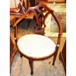 An Edwardian mahogany framed tub shaped boudoir elbow chair with oval seat panel, set on moulded