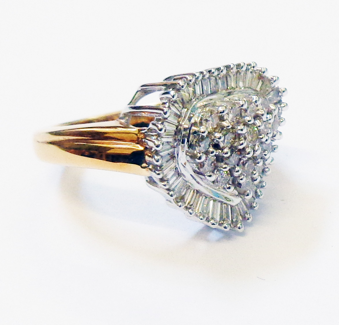 A hallmarked 750 gold heart shaped ring, set with diamond cluster within a baguette diamond border
