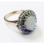 A marked 14k yellow metal ring set with damaged central opal within a diamond encrusted border (