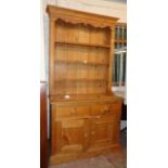 A 3' 5 1/2" reclaimed pine two part dresser with moulded cornice and three open shelves to plate