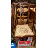 A set of four early 20th Century stained walnut and strung high back standard chairs with decorative