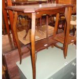 A 23 1/2" Edwardian walnut two tier occasional table with serpentine surfaces, set on slender