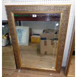 A modern gilt framed bevelled oblong wall mirror with decorative textured border - 3' X 26"