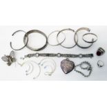 A collection of silver and white metal jewellery including bangles, heart shaped locket,