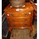 A 17 1/2" reproduction mahogany bow front bedside chest of three long drawers, set on cabriole