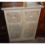 A 3' 10" vintage part stripped mixed wood cabinet with two drawers and shelves enclosed by a pair of