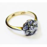 A marked 18ct. flowerhead ring, set with seven diamonds