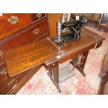 A vintage Singer treadle sewing machine with lamp and peddle