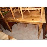 A 4' 3" stained pine farmhouse kitchen table with drawer to one end, set on turned legs