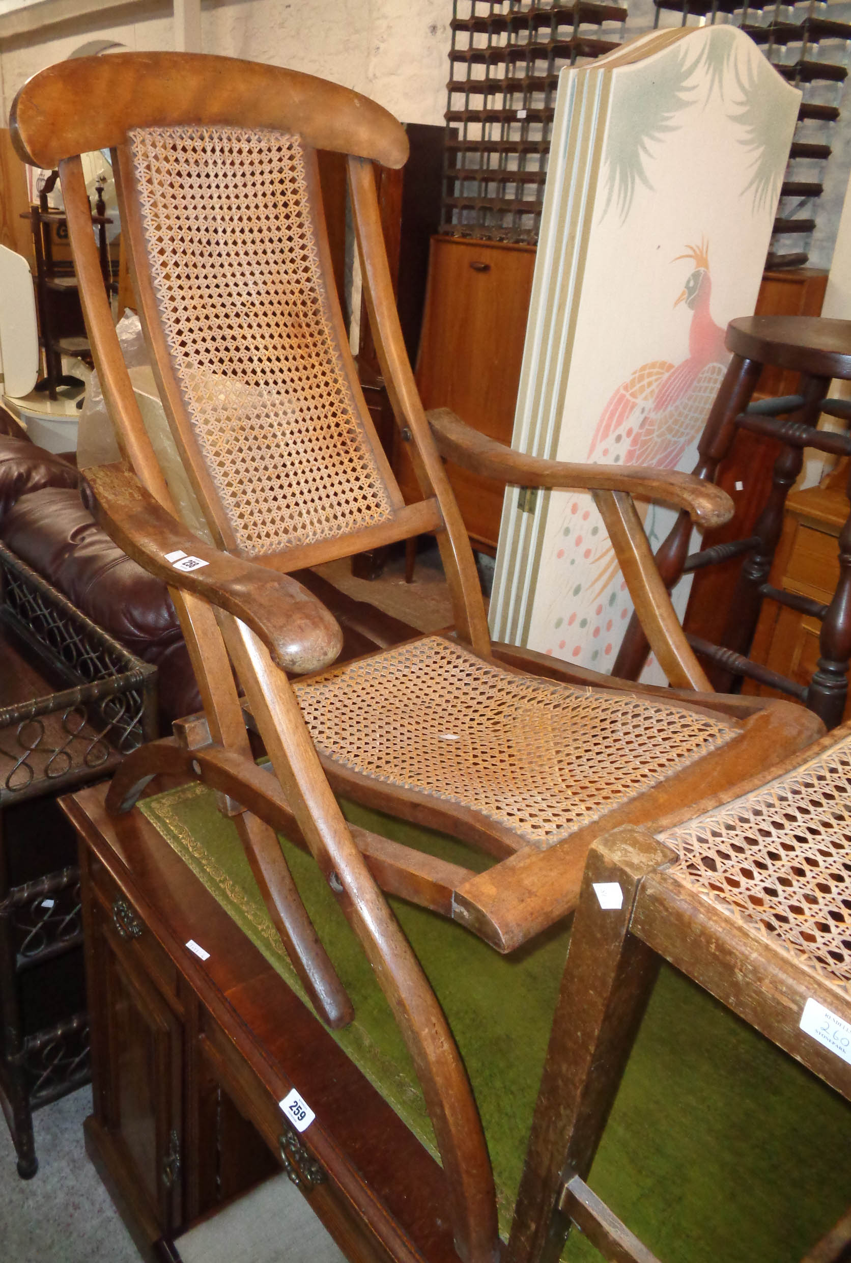 A vintage stained wood folding framed steamer style chair with rattan back and seat panels