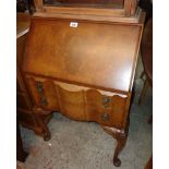 A 24" reproduction walnut and cross banded lady's bureau with fitted interior and two serpentine