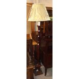 A 20th Century stained oak torchère style standard lamp and shade, set on turned pillar and pedestal