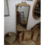 An ornate gilt framed narrow oblong wall mirror - sold with a similarly framed bevelled oval