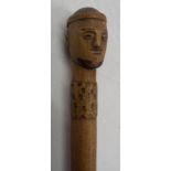 A carved wood walking stick with head pattern knop