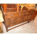 A 4' 7 1/2" 20th Century polished oak sideboard with two frieze drawers and quadruple linen-fold