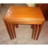 A nest of three retro teak finish tea tables, set on moulded square legs