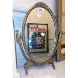 A vintage gilt framed oval dressing table mirror with ornate decoration