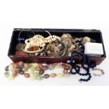 A lacquered box containing a quantity of assorted costume jewellery including hardstone beads, etc.