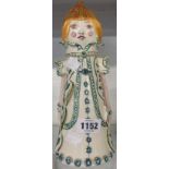 A vintage Jersey pottery stylized figure of a girl in a long coat