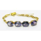 A marked 14k yellow metal fancy link bracelet, set with four oval alexandrite stones
