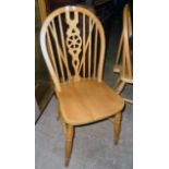 A set of four modern blonde wood wheel back kitchen chairs with solid sectional seats, set on turned