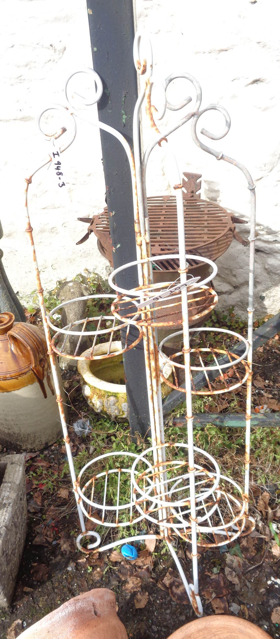 A painted metal folding plant stand