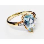 A hallmarked 750 14k gold ring, set with central pear cut Paraiba tourmaline and flanking