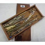 A wooden box containing assorted vintage drawing instruments