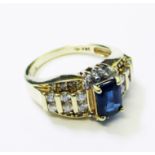 A marked 14k yellow metal ring, set with central oblong synthetic sapphire and six small diamonds