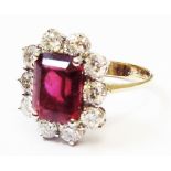 A hallmarked 750 gold ring, set with central emerald cut pink tourmaline within a ten stone