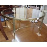 A 36 1/2" diameter brass framed coffee table with glass inset top, set on reeded supports and curved