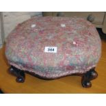 A Victorian mahogany footstool with remains of upholstered top, set on scroll cabriole legs