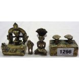 Four small brass items comprising Hindu shrine, Buddha with large fan, lidded box with stylized head