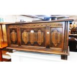 A 3' 1 1/2" 20th Century polished oak lift-top blanket chest with linen-fold panelled front and