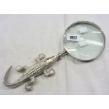 A reproduction magnifying glass with crocodile pattern cast metal handle
