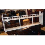 A 3' 6" painted wood wall mounted plate rack shelf with spindle decoration and shaped sides