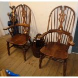 A pair of 20th Century Windsor style stained wood hoop stick back elbow chairs, with solid sectional