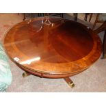 A 36" diameter reproduction quarter veneered and cross banded mixed wood coffee table with glass top