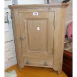 A 20" modern stripped pine wall mounted corner cupboard, with panelled door and drawer under