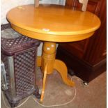 A 29 1/2" diameter modern blonde wood pedestal table, set on turned pillar and quadruple cabriole